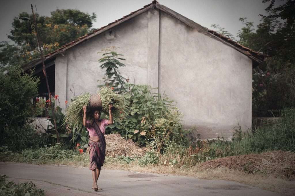 Young girl walking along a dirt path through a Ugandan village