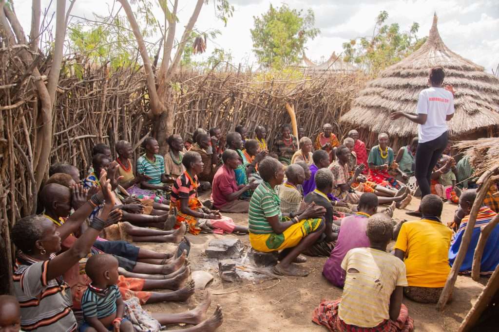 Community members meeting outdoors in a rural village