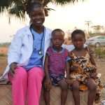 Community health worker engaging with local children during an outreach visit